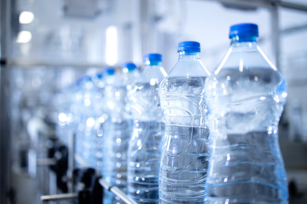 Close up view on plastic bottles of water in bottling factory be